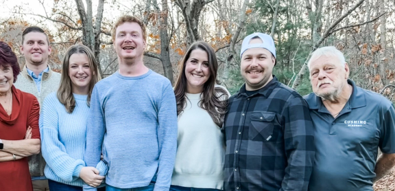 Carson and his family pose for a portrait outdoors.