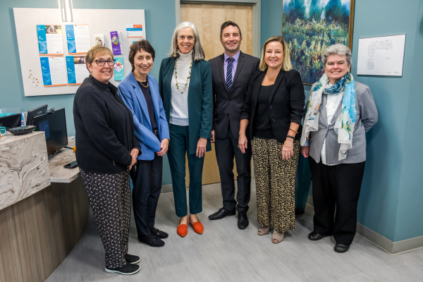 Six adults pose for the camera and smile