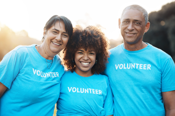 Portrait of happy people in a group volunteering outdoors.