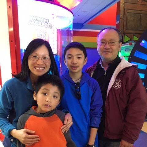 A family of four smiles in an arcade